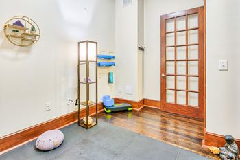 a yoga room with wood floors and glass doors